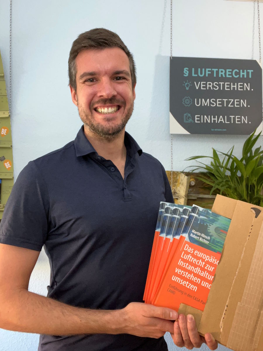 Robert Richter hält einige Exemplare vom frisch gedruckten Buch in den Händen